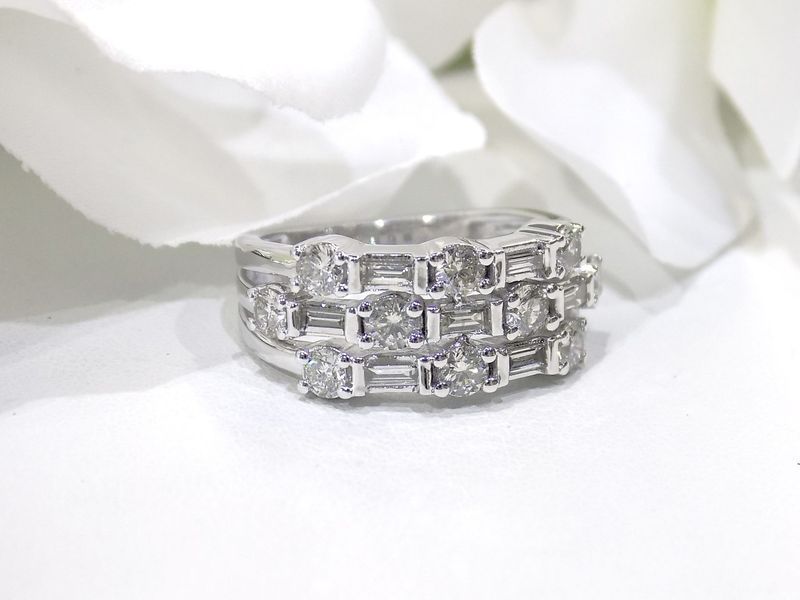 Three-row diamond ring on a white surface