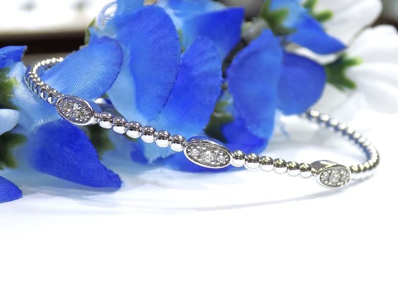 Silver bangle bracelet with three diamond-studded ovals