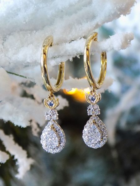 Gold hoop earrings with dangling diamond teardrops
