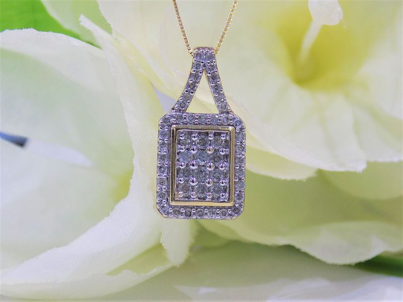 Gold pendant necklace with a rectangular diamond cluster and diamond accents