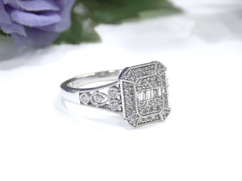 Diamond ring with emerald-cut center stone and surrounding smaller diamonds