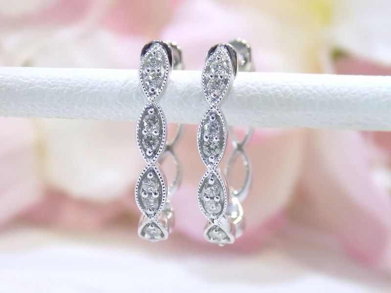 Diamond hoop earrings on a white rod
