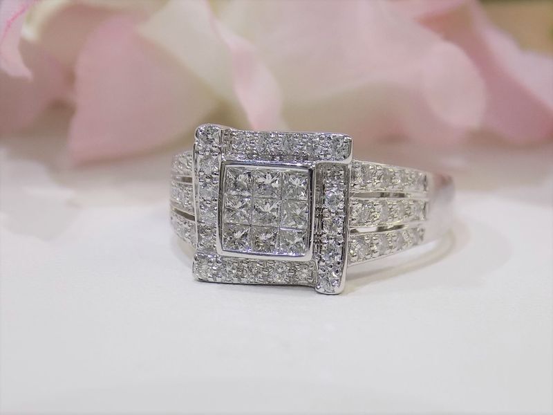 Diamond ring with a square cluster of stones on a white surface