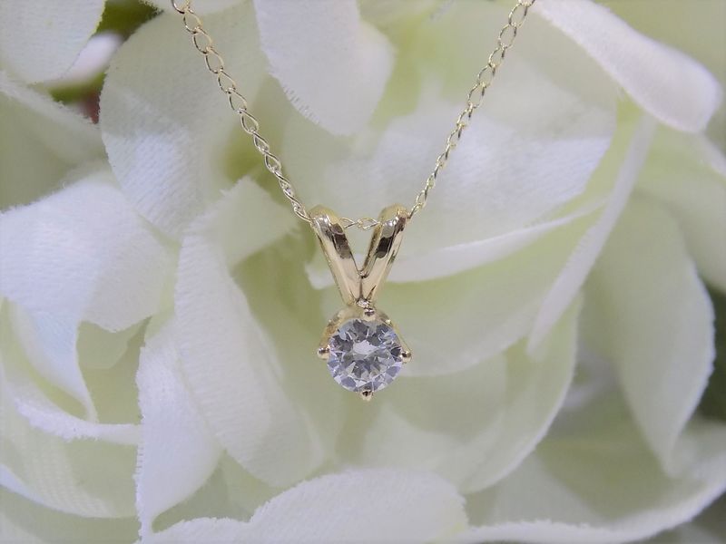 Gold pendant necklace with a round diamond