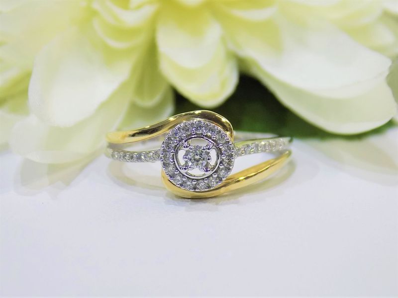 Diamond ring with a halo setting on a white surface