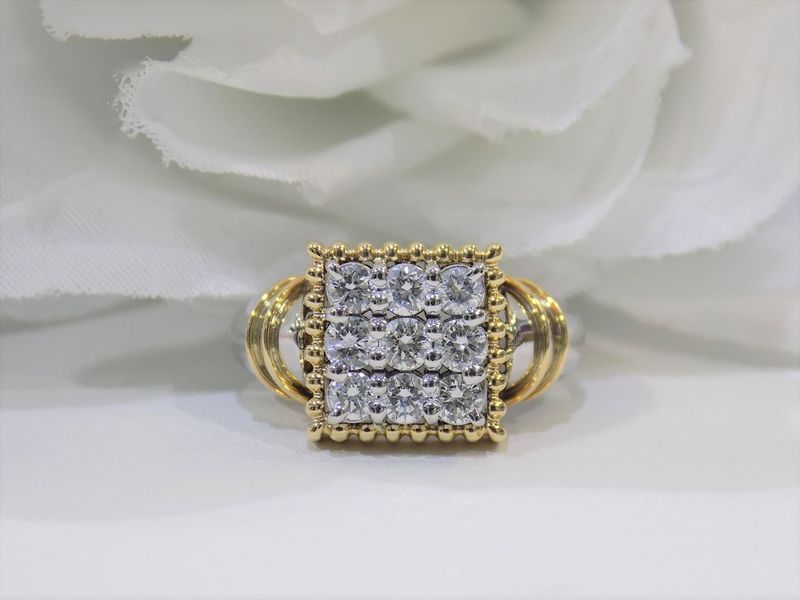 Gold ring with square diamond cluster on white surface