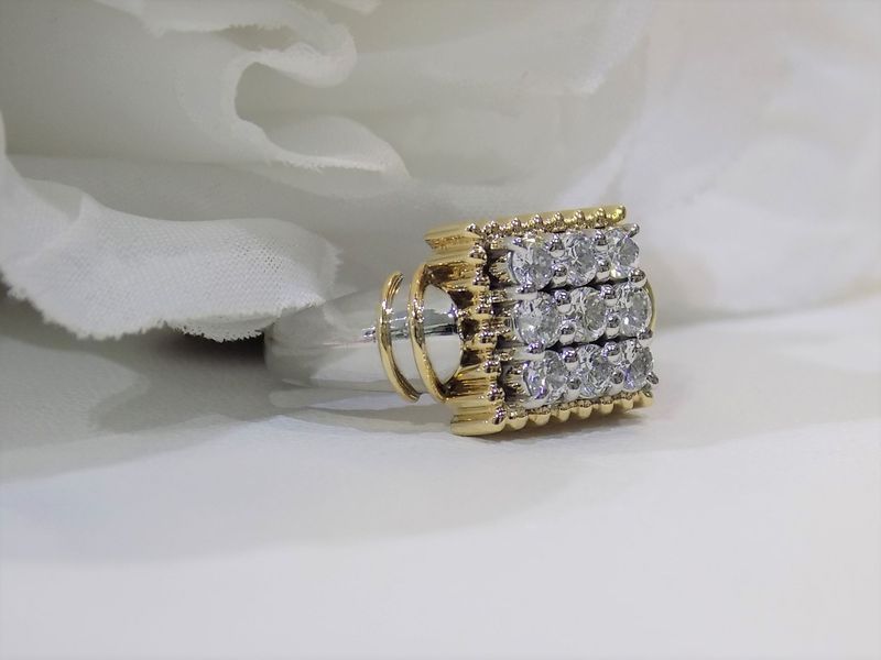 Gold and diamond square earring on a white surface