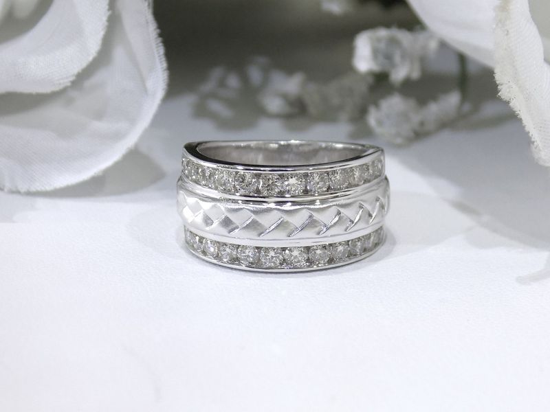 Wide silver ring with two rows of small diamonds and a textured center band