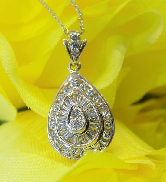 Diamond teardrop pendant necklace against yellow flowers
