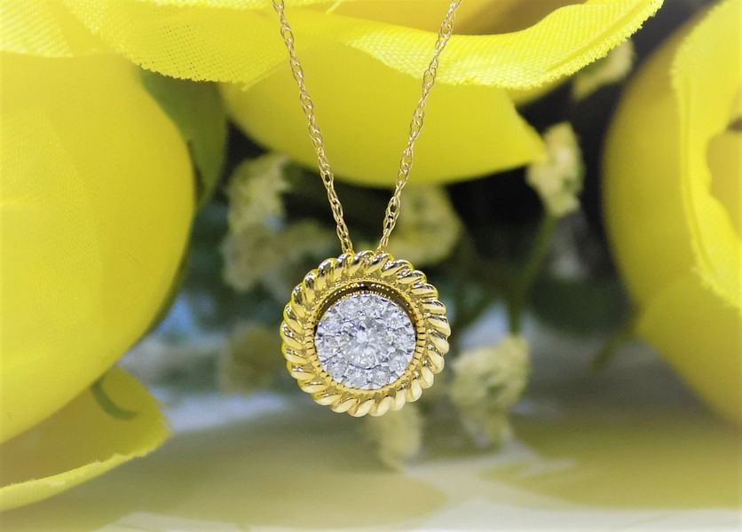 Gold necklace with diamond pendant, centered on yellow flowers