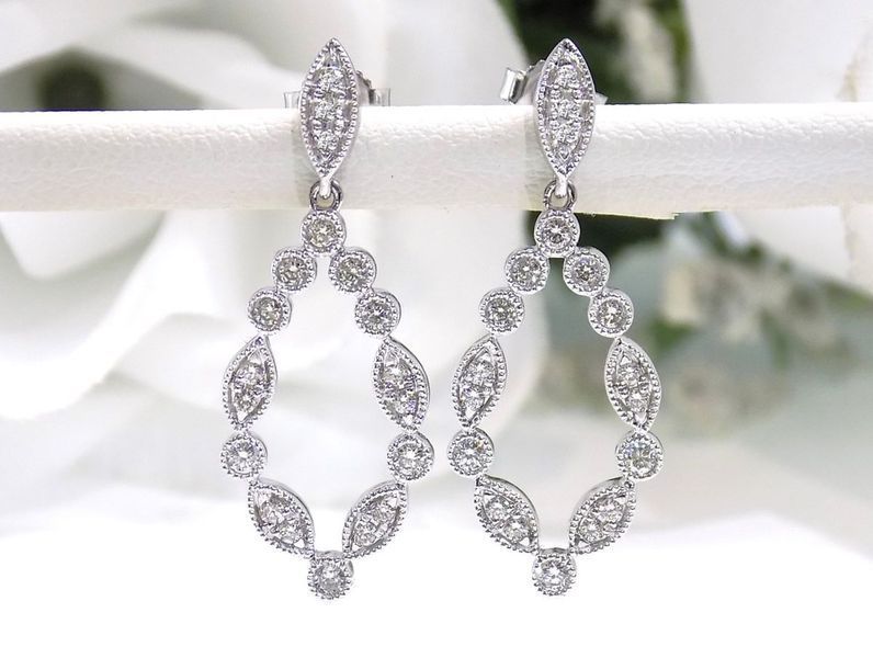 Diamond drop earrings with an oval shape and small diamond accents
