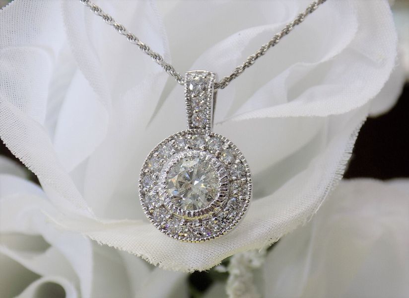 Diamond pendant necklace resting on a white flower