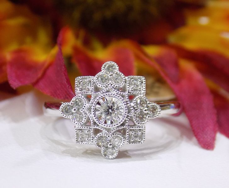 Diamond engagement ring with a floral design set against flowers