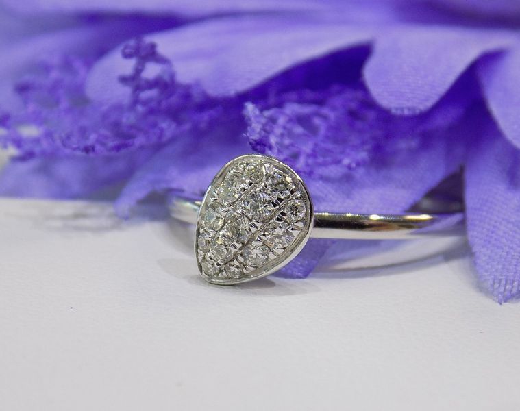 Silver ring with pear-shaped gray gem on a white surface