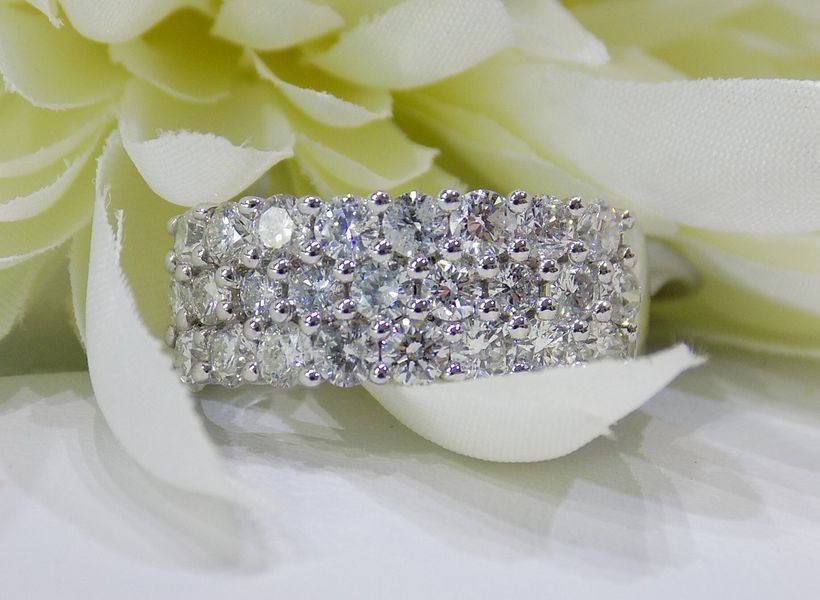 Diamond ring with two rows of sparkling stones on a white flower