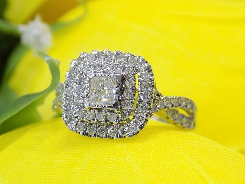 Diamond ring with a square center stone and halo setting