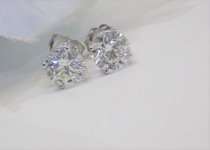Diamond stud earrings on white fabric