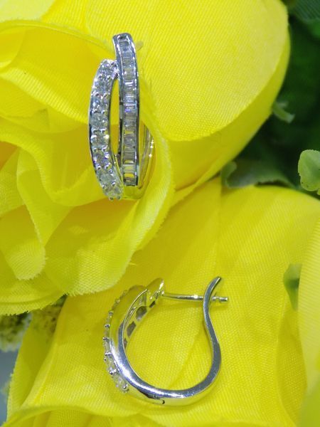 Diamond hoop earrings resting on yellow flowers