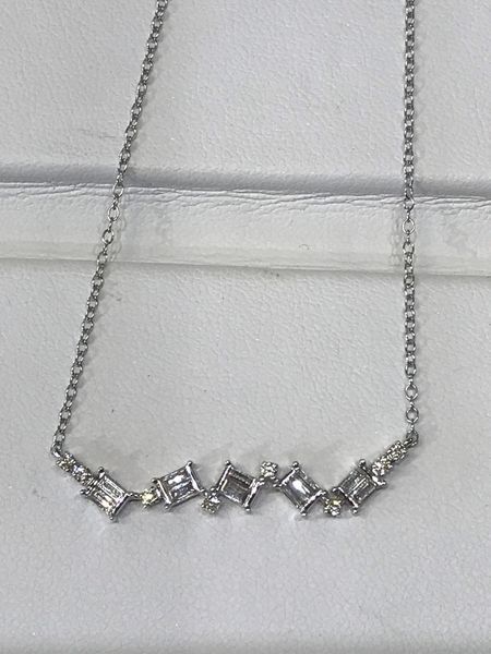 Silver necklace with baguette and round-cut diamonds arranged in a curved row