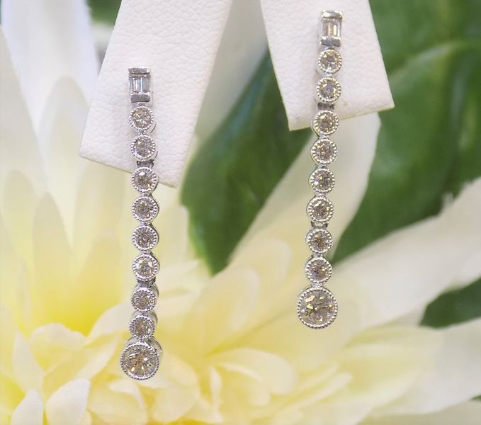 Dangling diamond earrings with a vertical row of round and baguette-cut stones