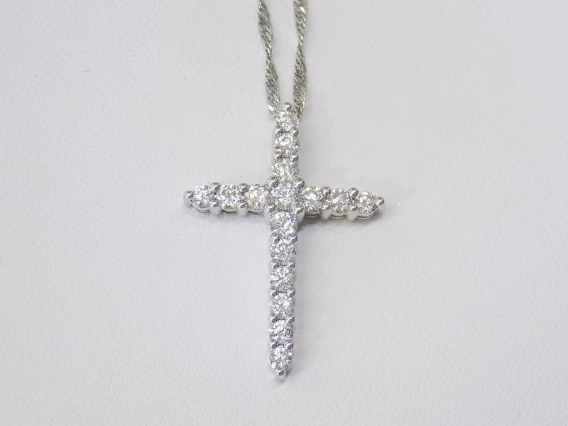 Diamond-studded cross pendant hanging on a silver chain