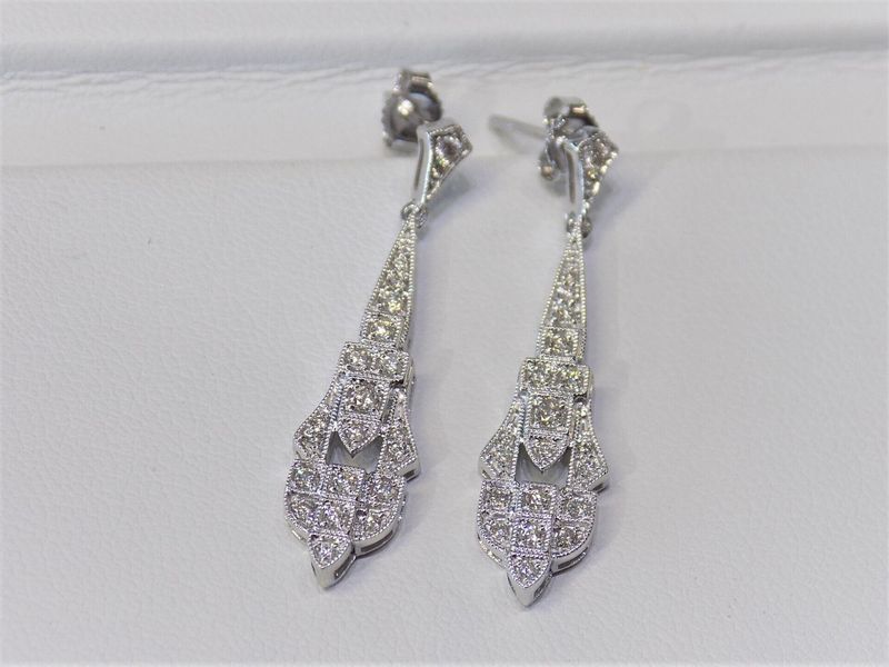 Dangling silver earrings with intricate diamond