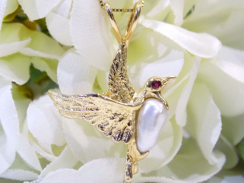 Gold bird pendant with pearl body and ruby eye