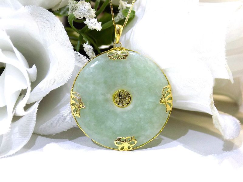 Jade pendant with gold accents on a gold chain
