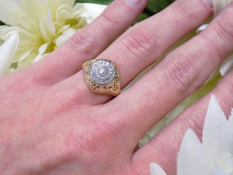 Hand wearing a gold ring with a circle of diamonds