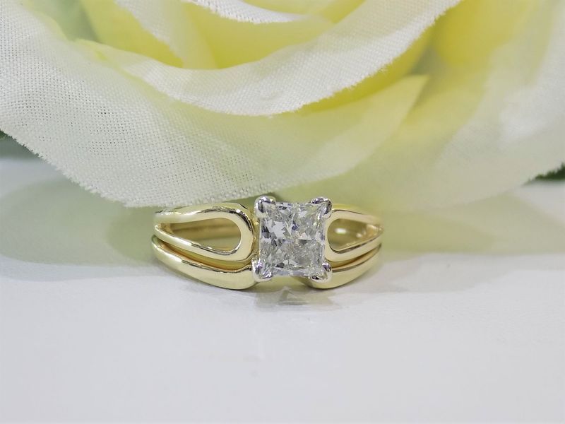 Yellow gold ring with a rectangular diamond on a white surface