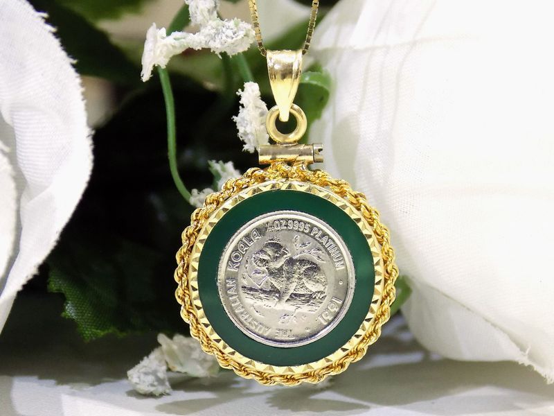 Gold pendant with a green border around a coin depicting a panda