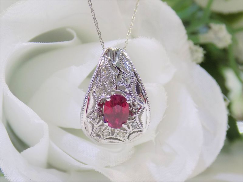 Diamond and ruby pendant necklace on a white rose