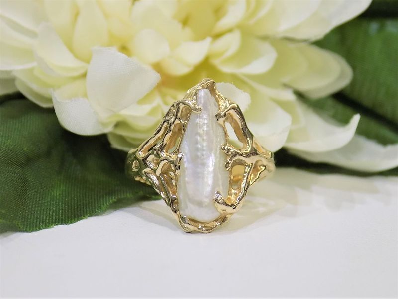 Gold ring with a long white pearl-like stone