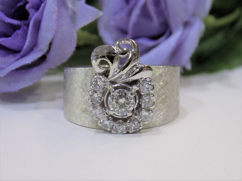Diamond ring with a wide, textured silver band and floral-shaped diamond cluster