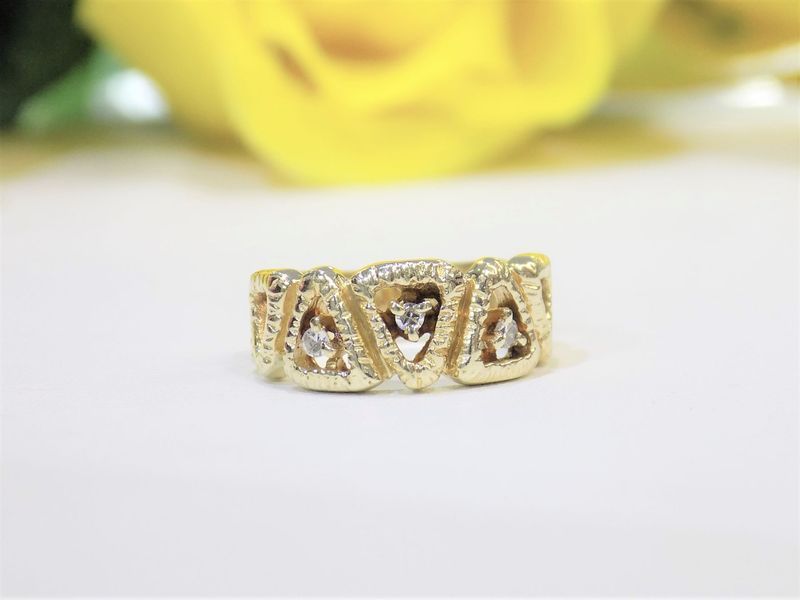 Gold ring with triangular designs and diamonds