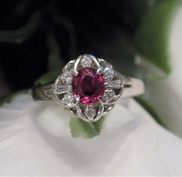 A ruby and diamond ring on a white surface