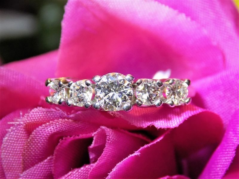 Diamond ring with three large stones on a pink flower