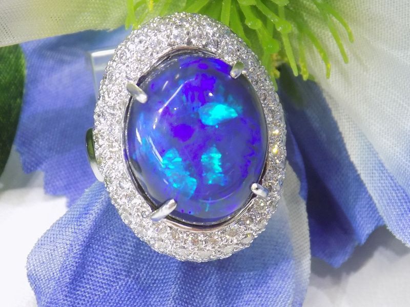 Oval black opal ring with a diamond halo