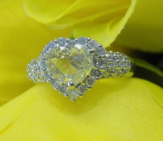 Heart-shaped diamond ring with a halo of smaller diamonds