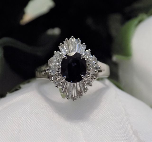 Oval sapphire ring with baguette and round diamonds on a white cloth
