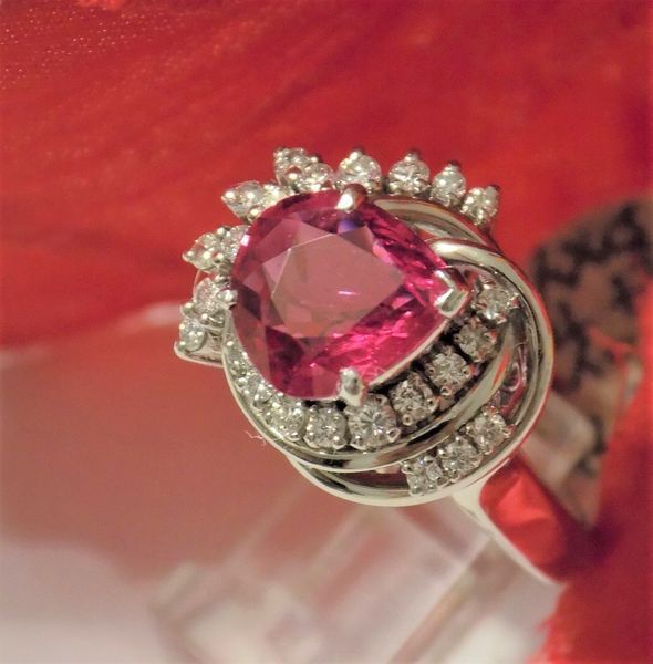 Diamond ring with a large pink gemstone on a red background