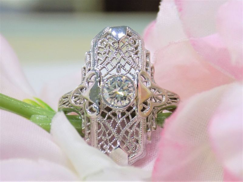 Filigree diamond engagement ring nestled in pink and white flower petals