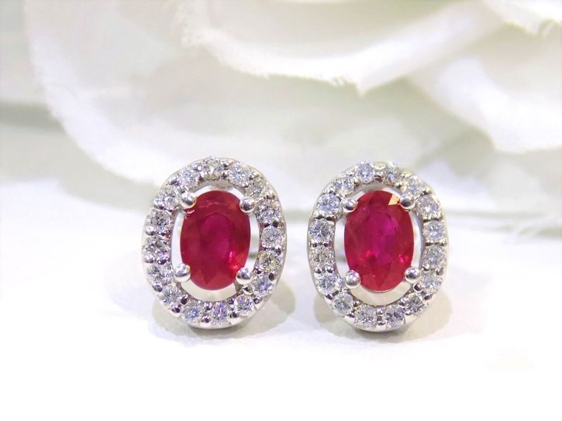 Oval ruby earrings surrounded by small white diamonds