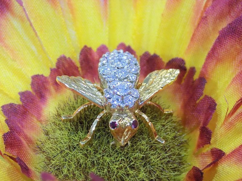 Jeweled bee brooch with light blue gems on a gold body