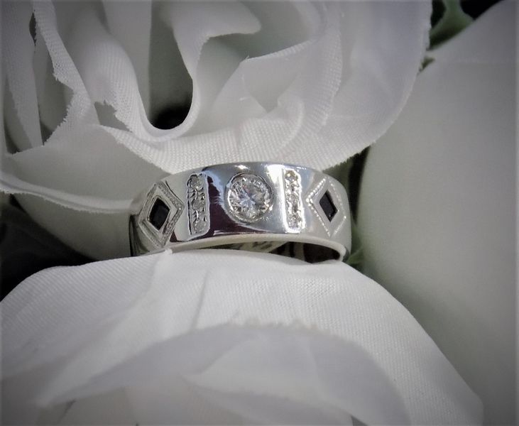 Silver ring with a central diamond and diamond-shaped black stones