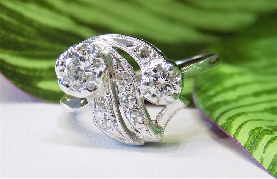 Diamond ring with two larger stones and smaller ones on an ornate