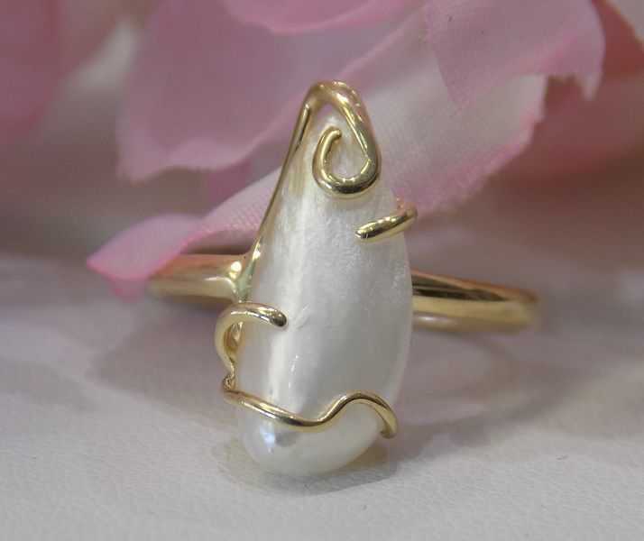 Gold ring with a pearly white teardrop-shaped stone wrapped in gold wire