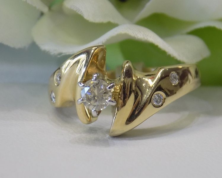 Gold ring with a diamond center and smaller accent diamonds