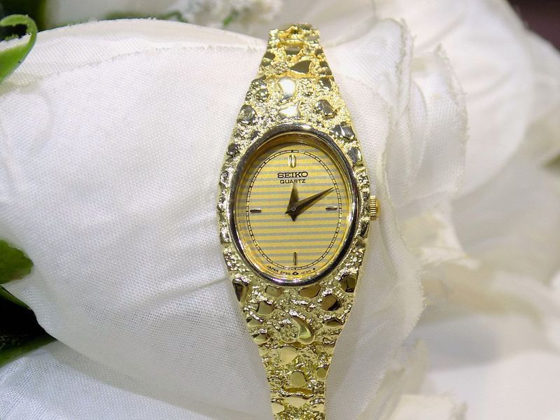 Gold Seiko quartz wristwatch with textured band and gold-toned face