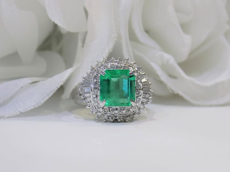 Emerald and diamond ring on white background